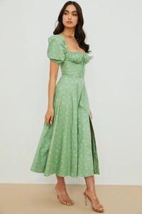 Close-up of sage green floral dress showing puff sleeves and high slit details