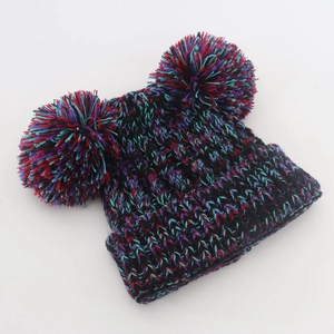 Detail of multi-color thick knit baby beanie with double fluffy pom-poms on white background