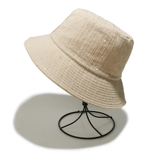 Détail d'un chapeau cloche beige avec texture plissée et petits ornements strass