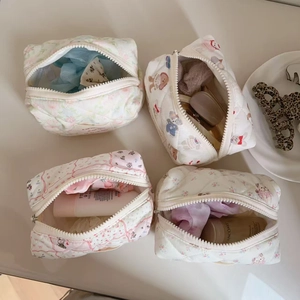 Top view of four quilted cotton makeup bags with floral and cartoon animal patterns