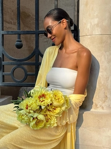 Detail of breathable yellow cardigan and white bandeau top for beach holiday style