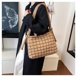 Detail of khaki quilted shoulder bag with unique knotted strap on female model