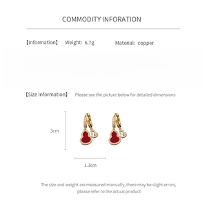 Macro view of gold-plated gourd earrings with red stones and zircon detailing