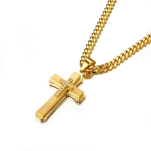 Close-up of golden multilayer cross pendant with zircon stones and cuban chain link