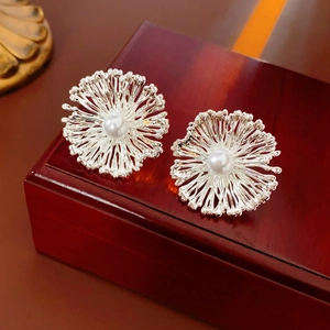 Elegant silver sunflower stud earrings with center pearl on dark wood gift box