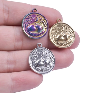 Detailed macro of fox and moon engraved pendants in gold, silver, and rainbow colors