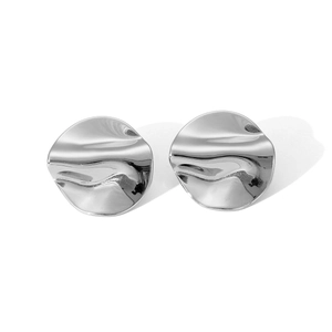Detail of silver irregular wavy disc earrings with a high-polished metallic surface