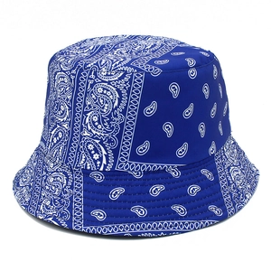 Blue reversible cotton bucket hat featuring classic white bandana paisley prints for sun protection