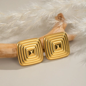 Chic gold square earrings with concentric geometric patterns on natural wood display