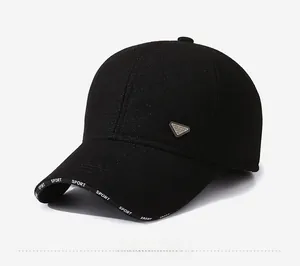 Detail of black winter sports cap showing the silver triangle logo and printed brim