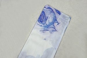 Detail view of white mesh sleeve with dark blue rose print on fine floral fabric
