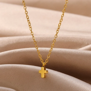 Elegant gold-plated stainless steel cross pendant necklace on soft satin fabric background