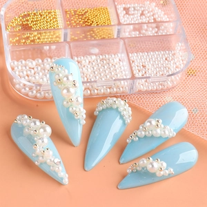 Detail of multi-size white pearls and gold beads in 12-slot case for nail art