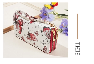 Detail view of double zipper wallet with red butterfly print and wrist strap