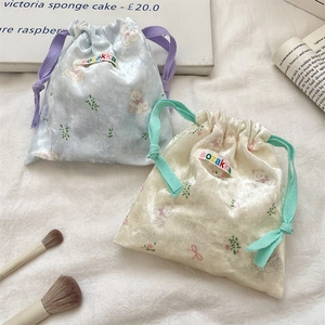 Detail view of velvet bear drawstring pouches with colorful ribbons on white cloth