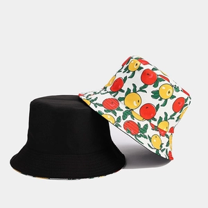 Detail of summer bucket hats in plain black and white citrus fruit print cotton fabric