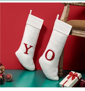 Detail of white knitted Christmas stockings with red embroidered letters Y and O