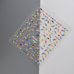 Macro view of 3D embossed floral nail art stickers with colorful patterns and rhinestones