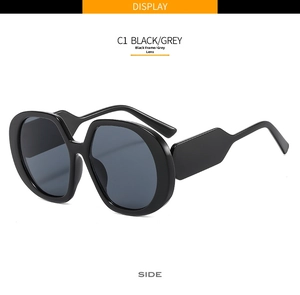 Detail view of large black frame sunglasses with grey lenses and geometric side temples