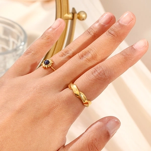Detail of 18K gold plated geometric ripple rings set with dark gemstone on model