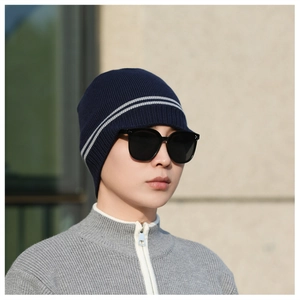 Detail of dark blue winter knit beanie with white stripes and warm thick texture