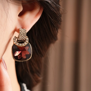 Detail of vintage square wine red gemstone earrings with sparkling diamond-set accents
