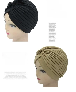 Detail of black and khaki pleated turban hats showing warm striped texture for winter