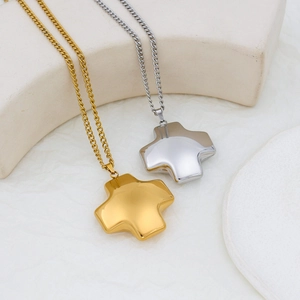 Polished minimalist gold and silver stainless steel cross necklaces on stone display