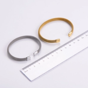 Detailed view of gold and silver mesh band open bracelets with measuring ruler scale