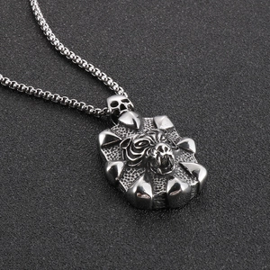Macro shot of silver tiger head pendant with skull connector on a stainless steel chain