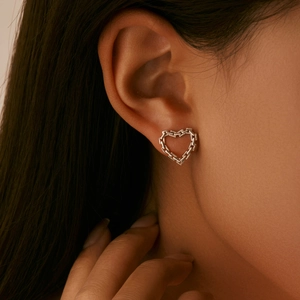 S925 sterling silver hollow heart chain stud earrings worn on female model ear