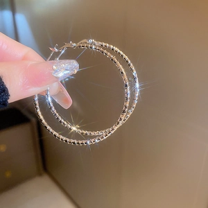 Macro shot of silver textured hoop earrings with sparkling starburst light effects