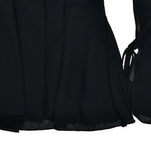 Detailed view of black chiffon dress hemline and sleeves with ruffled edges and stitching