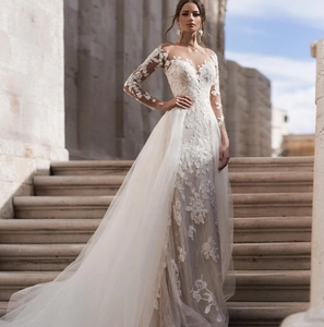 Detail of white long sleeve bridal gown with lace floral embroidery and v-neckline