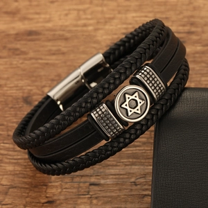 Detail of multi-layer black leather bracelet with silver Star of David charm and magnetic clasp