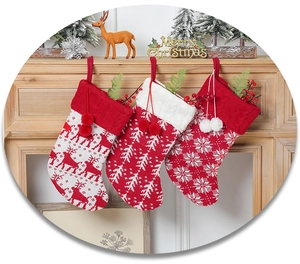Close-up of knit Christmas stockings with reindeer and snowflake patterns on a mantel