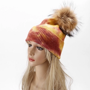 Detail of winter tie-dye knit beanie with fluffy pom pom on a display model