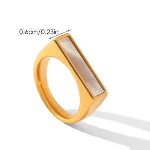 Macro shot of geometric gold stainless steel ring with rectangular white shell inlay