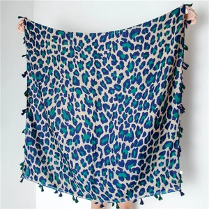 Detail of leopard print scarf with navy and green patterns and fringed tassel edges