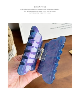 Detail of butterfly hair claw clip with purple and blue marble pattern and pearly finish