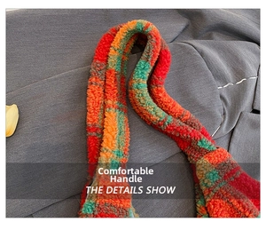 Detail of multi-color plaid teddy fleece handbag strap with vibrant orange and green fibers