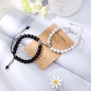 Detail of magnetic stone bracelets for couples with pinky promise card on blue background
