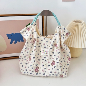 Detail of cartoon bear and purple floral pattern on white embossed canvas tote bag