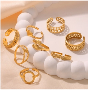 Detailed set of seven gold-plated stainless steel rings on a white cloud tray