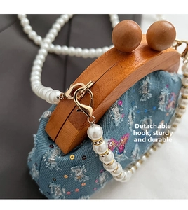Detail of blue denim bag with sequins, wooden clasp and detachable pearl chain strap