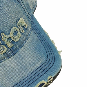 Dettaglio del berretto in denim con ricamo BOSTON in rilievo e finiture sfrangiate