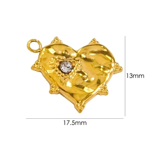 Macro shot of 13mm heart-shaped gold pendant with central crystal and hammered texture