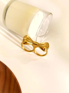 Vue détaillée d'une bague double en or poli avec un grand motif de nœud en 3D