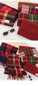 Flat lay of warm plaid scarves with fringes in various colors for winter season