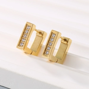 Close-up of golden square titanium steel earrings with five vertically set white zircons